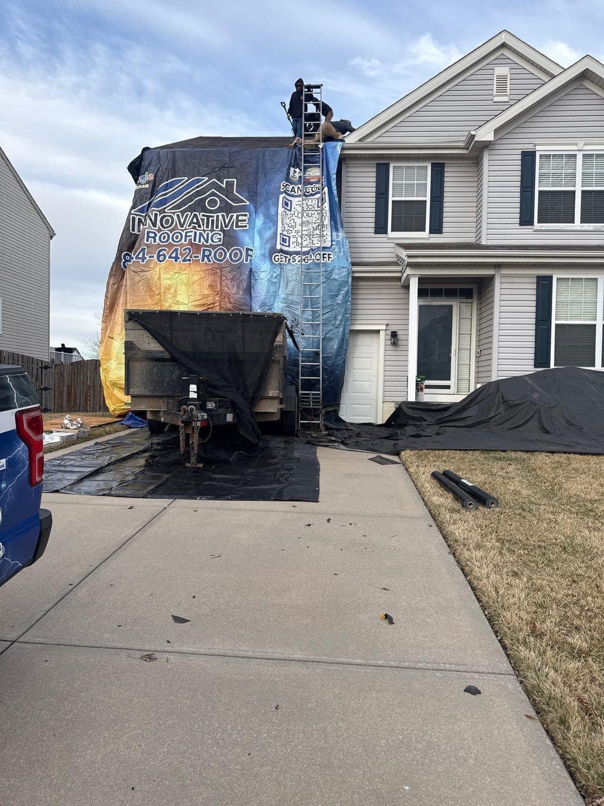 Innovative Roofing crew protecting a home with tarp on the job