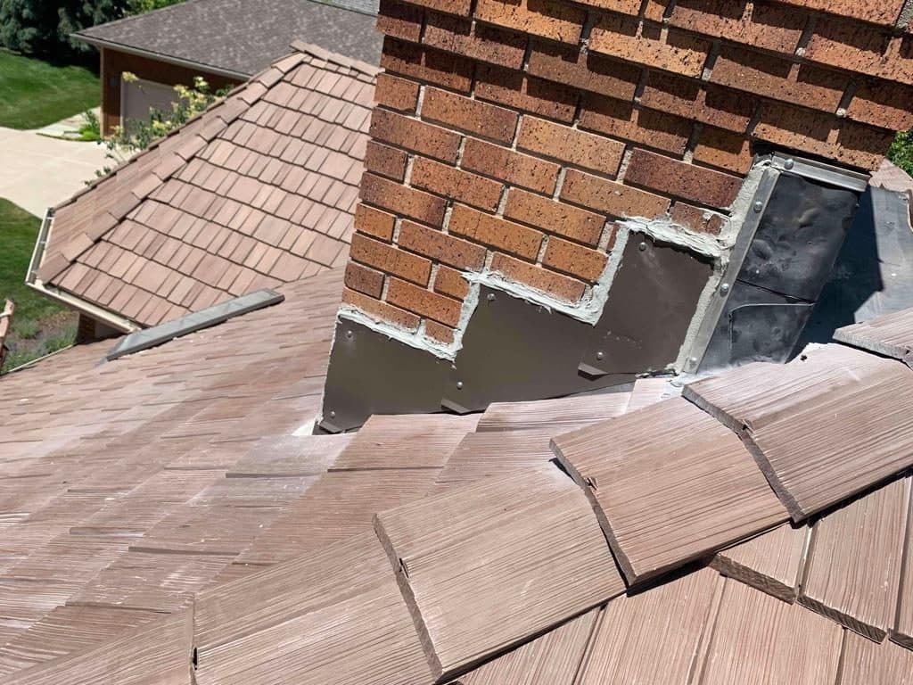 New step and counter flashing where a roof meets a brick chimney