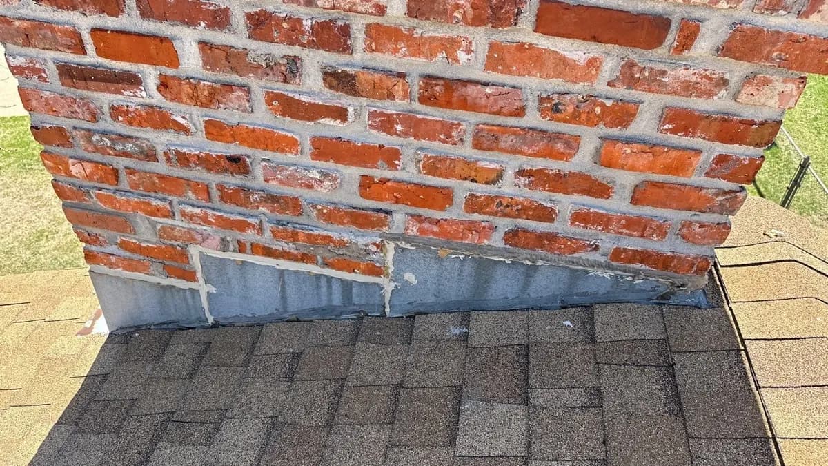 Metal flashing where a brick chimney meets the shingles on an Omaha-area roof
