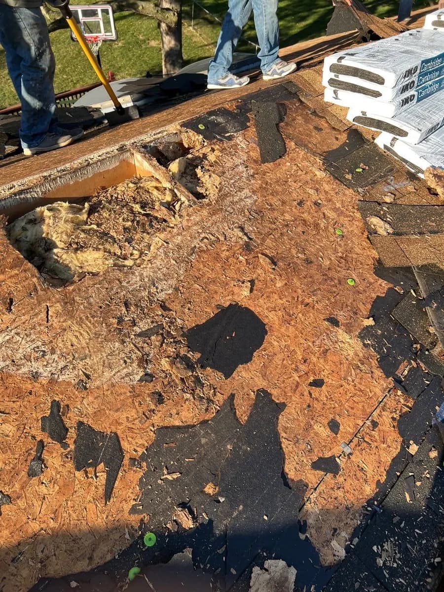 Rotted roof decking exposed on an Omaha-area home, with the crew working nearby