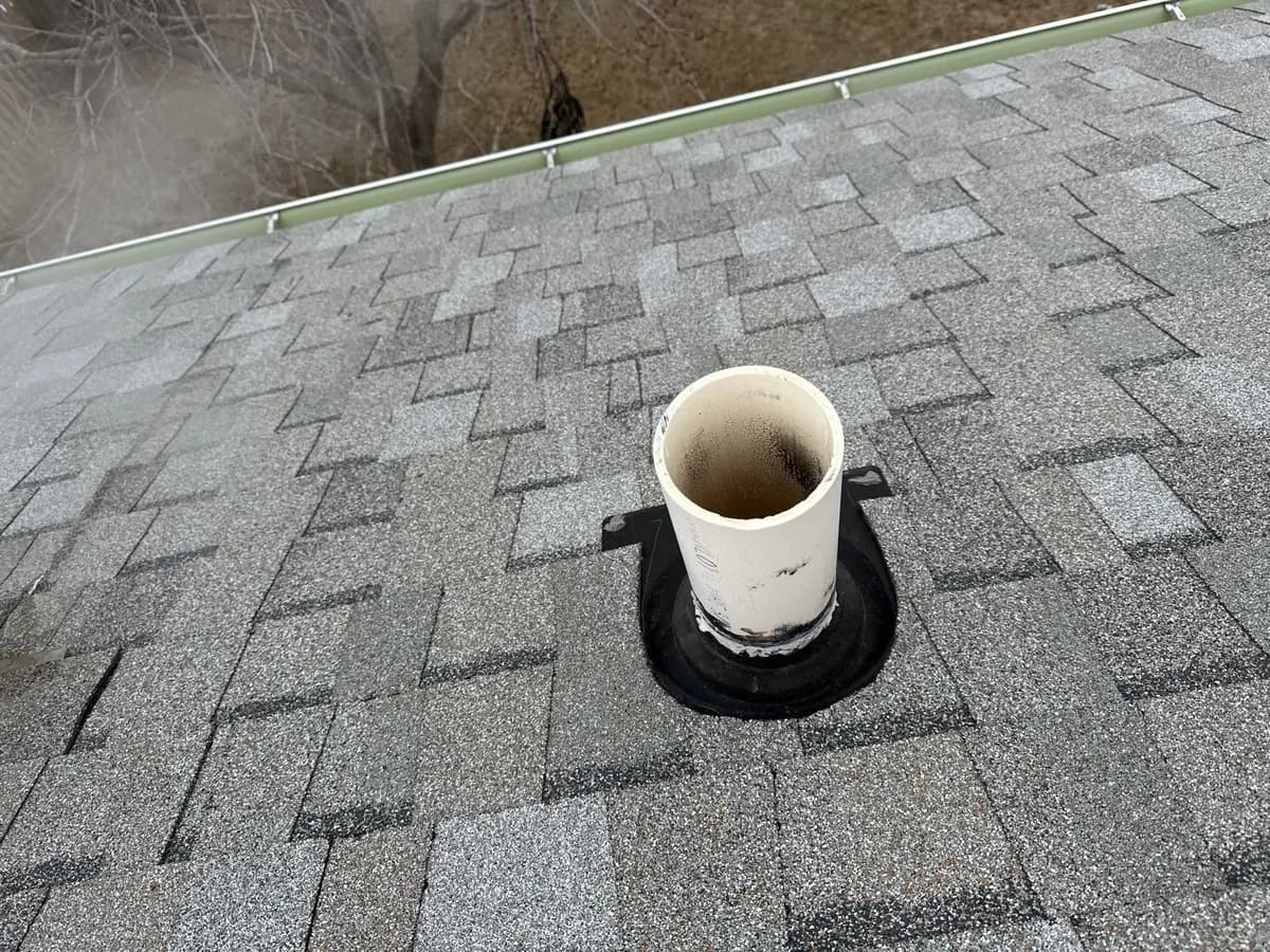 Plumbing vent pipe and rubber boot on a gray shingle roof in the Omaha area