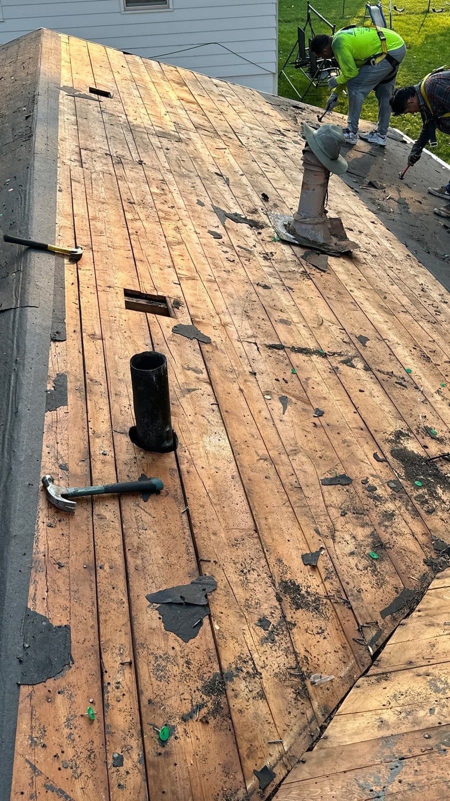 Roofing crew during tear-off on a residential roof, preparing the deck for repair or replacement