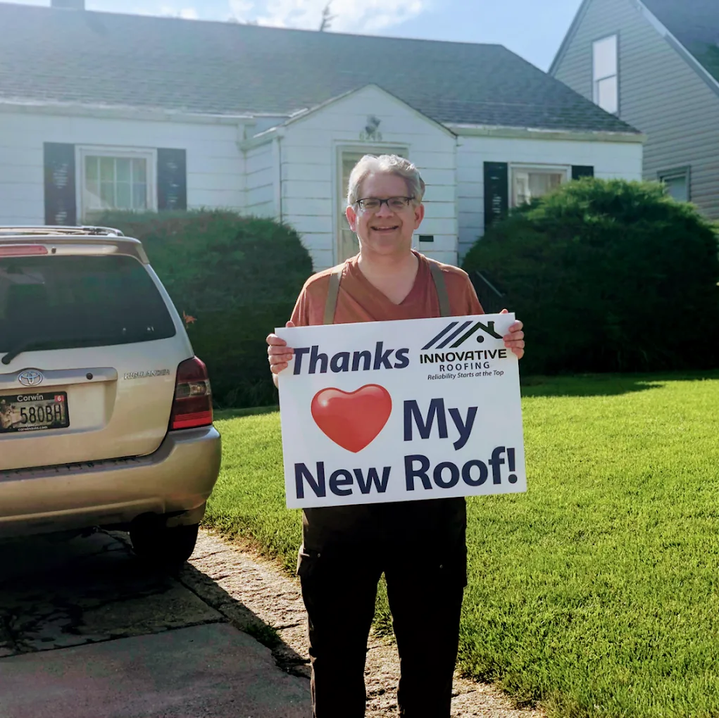 Omaha homeowner holding a Thanks, I love my new roof sign